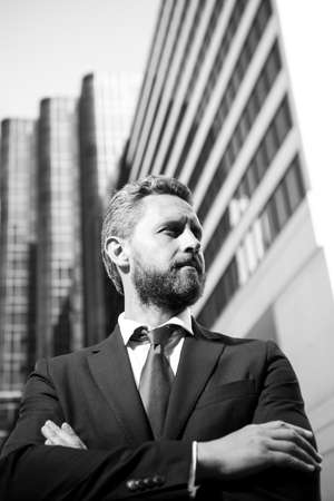 Portrait of businessman standing in a office. Entrepreneur, business portrait. Businessman standing proud with arms crossed outside.の写真素材