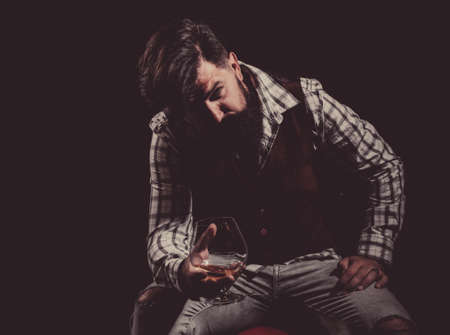 Alcoholic addiction - get the treatment you need. Drunk man holding whisky glass after he drank a lot of alcohol and feeling headache. Alcoholic concept.の写真素材