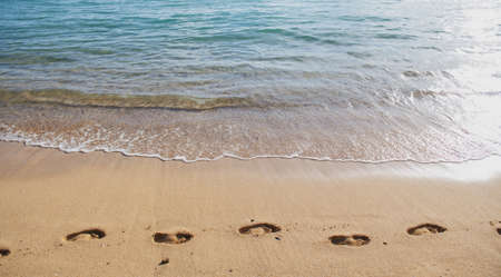 Beach background footprints in sand foot print. Concept for travel vacation. Footsteps in sand on...