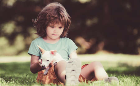 Child with her doggy lying on lawn. Cute kid enjoying with her best friend dog.の写真素材