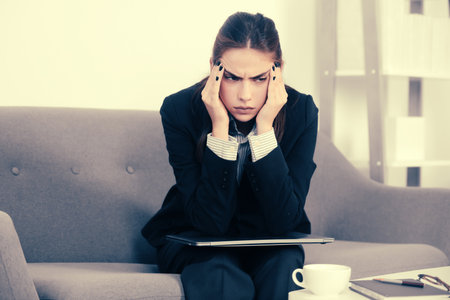 Busy business woman, secretary girl working alone late in office. Angry sad secretary, upset accountant employee at workspace.の写真素材