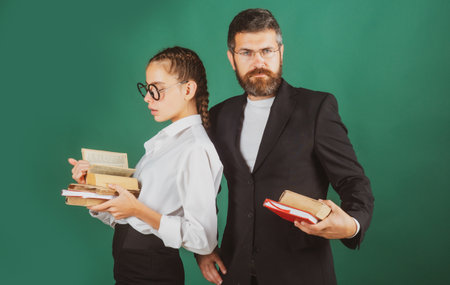 Cheerful smiling little student girl and teacher in school uniform. Education, high school and people concept.の写真素材
