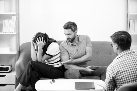 Social worker psychologist talking to young couple. Couple telling the psychologist about marital...