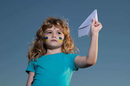 Close sky help now and Ukrainian flag. Protest against war in Ukraine. Close the sky over Ukraine banner. No fly zone over Ukraine. Ukraine flag on kids cheek. Military ukrainian aircraft.の写真素材