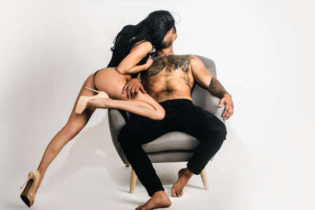 Sexy young couple of undressed sensual man and nude woman with naked muscular body. Couple in love. Athletic man kissing and embracing romantic woman. Sexy elegant couple in the tender passion.の写真素材