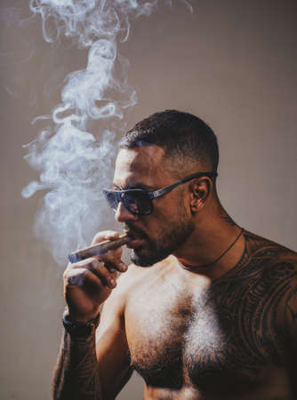 Portrait of handsome man with serious face smoking cigar. Mafia boss.の写真素材