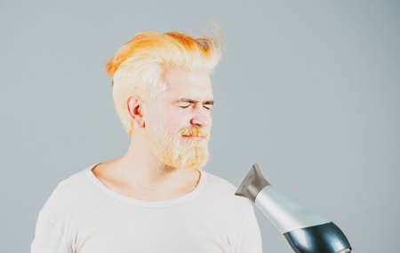 Blonde funny bearded man hair dry. Hair care male isolated.の写真素材