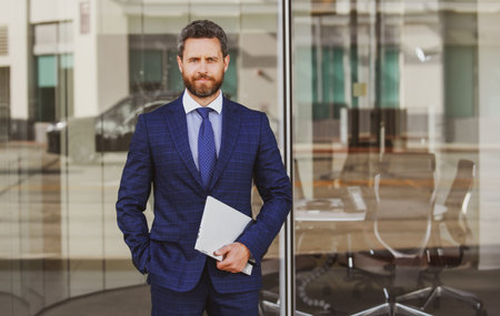 Portrait of handsome businessman using laptop outdoor.