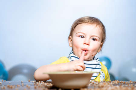 Babies eating, healthy food for a baby. Funny kid boy with plate and spoon.の写真素材