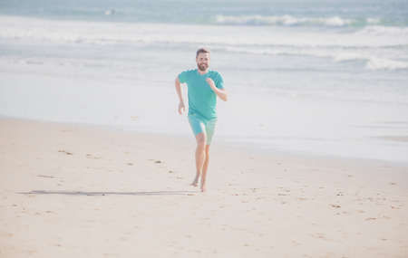 Man running. Male runner athlete run on sandy beach.の写真素材