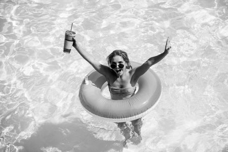 Girl swimming pool. Summer vacation. Woman in swimsuit on inflatable circle in the swimmingpool.