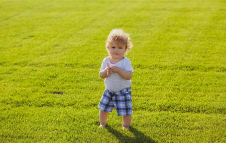 Baby in beautiful spring green field. Healthy child.の写真素材