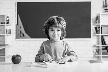 Child near chalkboard in school classroom. Child home studying and home education. Kids gets ready for school.の写真素材