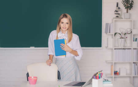 Portrait of a young, confident and attractive female student studying in school classroom. Learning and education concept.の写真素材