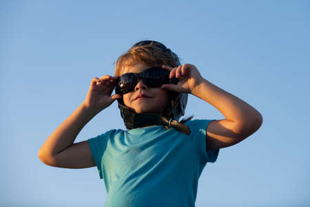 Little boy with pilot goggles and helmet, boy wants to become pilot and astronaut. Happy child play...