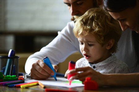 Happy family portrait having fun together. Kids early arts and crafts education, drawing. Father mother and child son drawing at home. Early childhood education, kids creative growth.の写真素材