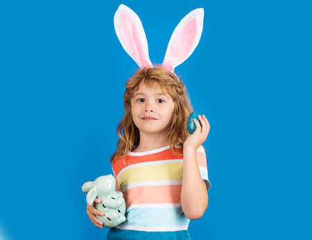 Happy Easter for children. Child hunting easter eggs, isolated on blue background.