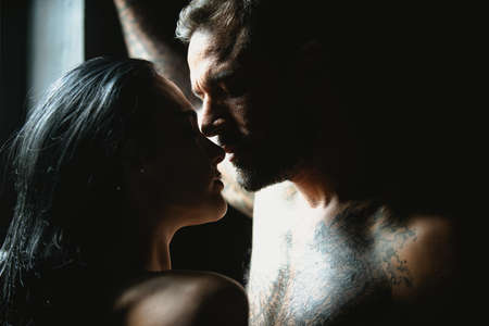 Close-up of young romantic couple is kissing each other. Sexy elegant couple lovers in the tender passion. Portrait of lovely sexy couple in love. Man kiss sensual woman. Romantic couples embraces.の写真素材