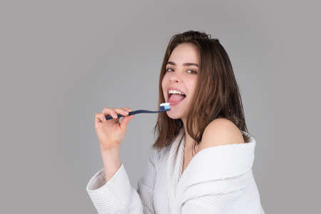 Closeup portrait of womans toothy smile against a isolated background with copy space. Girl brushing her teeth. Beautiful young woman smile. Dental health. White tooth.の写真素材