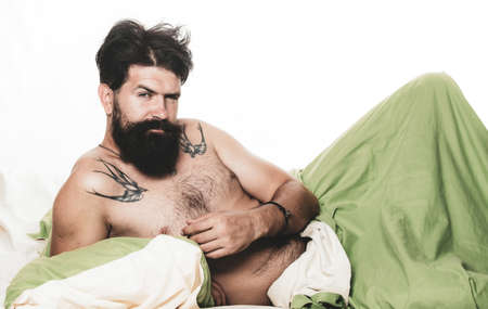 Good morning. Wake up. Young man sleeping in bed with pillows at home. Man lying in bed and sleeping.の写真素材