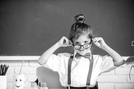 Cute child at school. Kid is learning in class on background of blackboard. First day at school.の写真素材