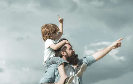 Happy fathers day. Dad and son are playing on sky backgroundの写真素材
