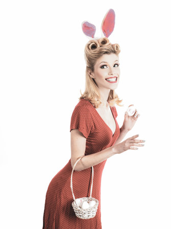 Sexy model dressed in costume Easter bunny. Isolated white background. Sweet adorable girl in bunny ears celebrating Easter. Hunting eggs. Pinup woman in bunny ears with Easter egg.の写真素材