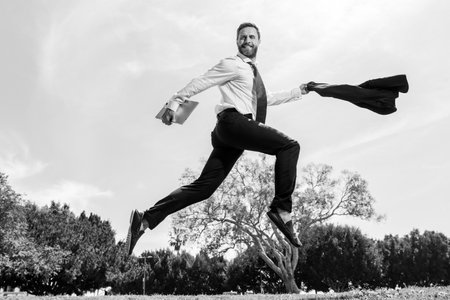 Business man in suit jumping over urban park. Fast business concept.の写真素材