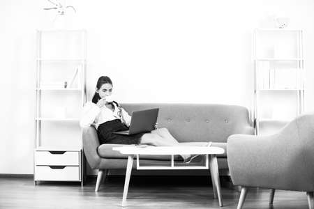 Break time concept. Business woman entrepreneur drinking coffee working in office, professional employee at workplace. Young beautiful secretary girl.の写真素材