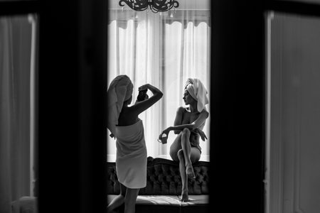 Sexy girls making photoshoot. Female photographer with camera taking pictures of girl friend. Naked female photo model. Best friends forever. Funny leisure, weekend, holiday in europe.の写真素材