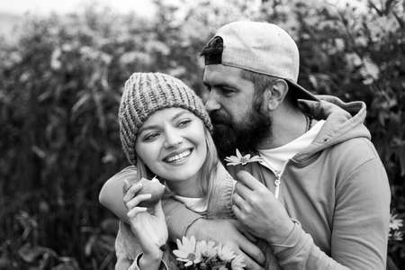 Sensual portrait of young couple in love in autumn park with flovers. Loving couple embracing and kissing.の写真素材