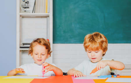Happy cute clever boys pupils drawing. Kids funny education. Preschool childrenhaving fun in classroom. Kids ready for school.の写真素材