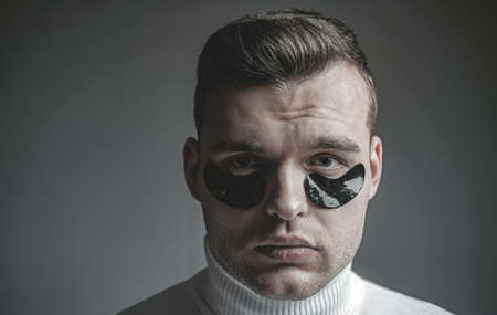Skin care. Minimizes puffiness and reduce dark circles. Eye patches for men. Man with black eye...