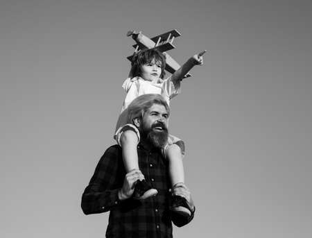 Cute boy with dad playing outdoor. Son and father playing. Kid pilot aviator and daddy dreams of traveling.の写真素材
