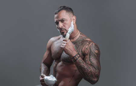 Master hairdresser does hairstyle and style with scissors and comb. Portrait of stylish man beard. Hair Stylist and Barber. Advertising and barber shop concept. Razor blade.の写真素材