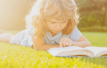 Cute childr boy with books outdoors. Summer camp. Kids learning and education concept.の写真素材