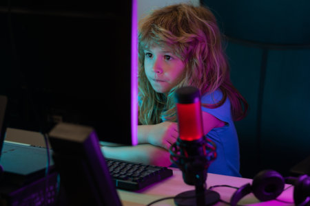 Little child gamer play computer game on desktop. Gaming stream and blogging for kids. School,...