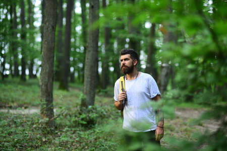 Hiker man hiking in forest. Male hiker walking in forest. Hiker with backpack hiking in beautiful forest. Caucasian male model outdoors in nature.の写真素材
