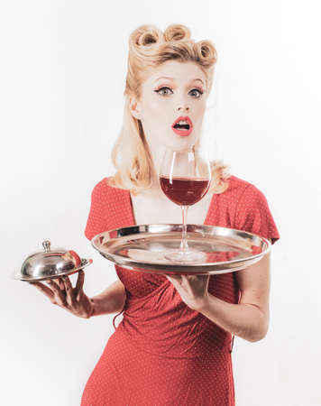 Happy girl with glass of wine. Red lips. Woman studio photography. Beauty. Happy excited woman in retro dress with beautiful hairdo. Fashion.の写真素材
