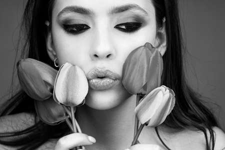 Spring woman fashion concept. Womens day, 8 march. Fashion beauty girl with tulip fields. Close up portrait.の写真素材