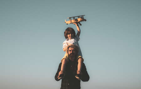Father and son happy family. Father carrying his son on shoulders.の写真素材