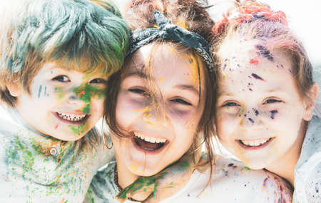 Close up portrait of happy excited litttle kids on holi color festival. Cute children with colorful paint powder on faces.の写真素材