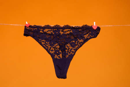 Lace panties. The sexy panty isolated on the yellow background. Black silk lacy panty, woman...