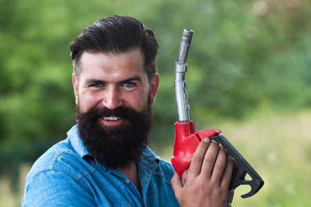 Man with gasoline pump nozzle. Fuel pump petrol station. Gas station. Petrol or gasoline being...