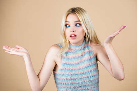 Confused beautiful blonde woman with questioning gesture. Girl shrugging shoulders, doubts.の写真素材