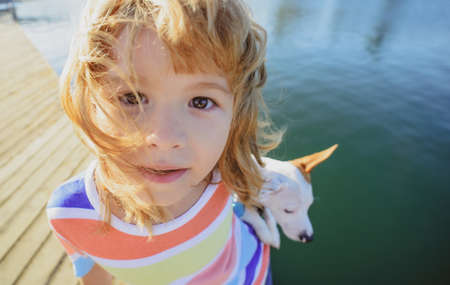 Wide angle kids face. Child lovingly embraces his pet dog.の写真素材