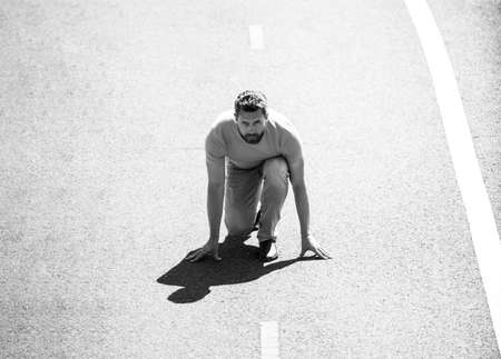 Full length of healthy man running and sprinting outdoors on road. Male runner on start.の写真素材