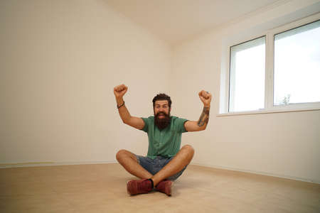 Excited man moving to new home. Moving to a empty apartment.の写真素材