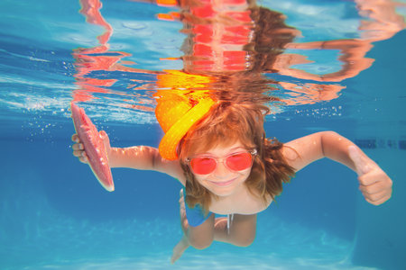 Kid swimming in pool underwater. Child boy swim under water in sea.の写真素材