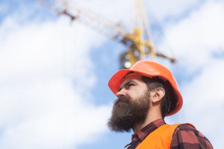 Construction worker man in work clothes and a construction helmet. Building and construction site...